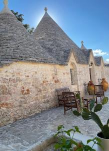 a brick building with chairs and tables in a courtyard at Trullo Ronzicchio in Cisternino