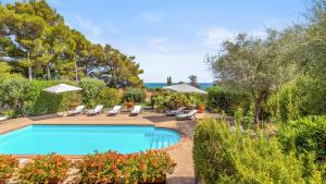 a pool with chairs and umbrellas in a yard at VILLA FIORILLO 6, Emma Villas in Orbetello