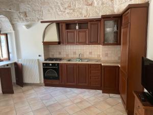 La cuisine est équipée de placards en bois et d'un four avec plaques de cuisson. dans l'établissement Trullo Ronzicchio, à Cisternino