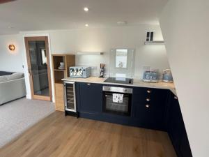 a kitchen with a stove and a counter top at Crow’s Nest, Waverley Apartments in Gourock