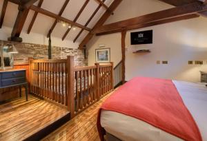 1 dormitorio con 1 cama y suelo de madera en Peterstone Court Country House Restaurant & Spa, en Brecon