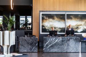 a lobby with two tables with laptops on them at Clarion Hotel Copenhagen Airport in Copenhagen