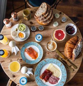 una mesa de madera cubierta con platos de comida y pan en Padstow Townhouse en Padstow