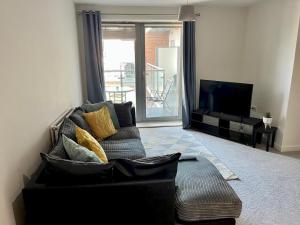 een woonkamer met een bank en een televisie bij Pass the Keys Central Watford Apartment Sleeps 5 with Parking in Watford