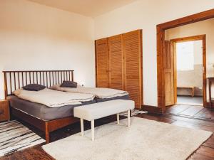 a bedroom with a bed and a bench in it at Ferienwohnung Brühler Hof in Bad Berka