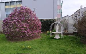 una estatua en un patio junto a un arbusto con flores púrpuras en Ring Gasthaus, en Zeltweg