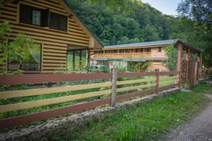 a wooden fence in front of a house at Casa din Pădure in Petroşani
