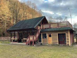 a log cabin with a large deck and a staircase at Casa din Pădure in Petroşani +32 photos