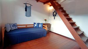 Un dormitorio con una cama azul y una escalera en Solar das Pétalas Guest House, en Florianópolis