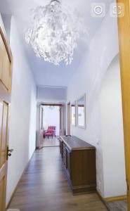 a kitchen with a chandelier and a hallway with a table at ArLange in Ventspils
