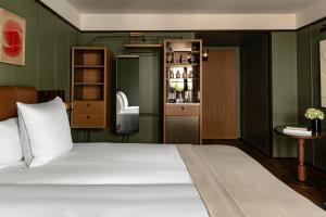 ein Schlafzimmer mit einem weißen Bett und einer grünen Wand in der Unterkunft Hotel Norman Paris in Paris
