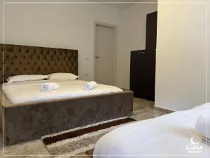 - une chambre avec 2 lits et une grande tête de lit dans l'établissement Luna Resort, à Peje