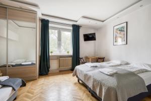 a bedroom with two beds and a window at Labo Apartment Ogrodowa in Warsaw