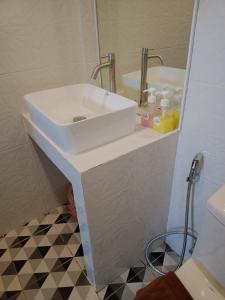 W łazience znajduje się biała umywalka i lustro. w obiekcie Kipbox Hotel Trang w mieście Trang