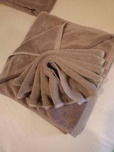 een bruine handdoek bovenop een tafel bij Kipbox Hotel Trang in Trang