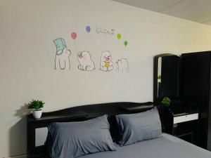 a bedroom with a bed with drawings of cats on the wall at Condo popular T8 Fl.5 in Thung Si Kan