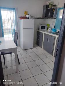 a kitchen with a table and a white refrigerator at Villa Saphira in Antananarivo