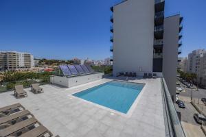 uma piscina no telhado de um edifício em Terracos de Quarteira II Purple by Real Properties em Quarteira