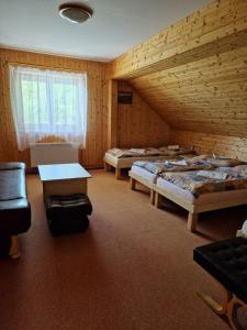 a room with three beds and a table in it at Hostinec u Řeky in Ostravice