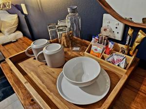 a wooden tray with two cups and bowls on it at Villa-né Guesthouse in Potchefstroom
