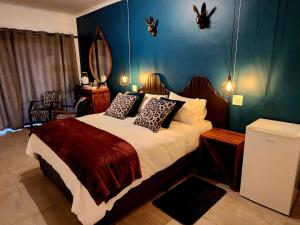 a bedroom with a bed with a mirror on the wall at Villa-né Guesthouse in Potchefstroom