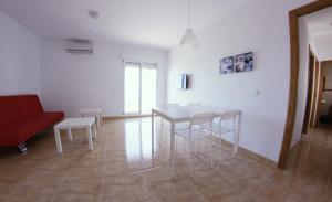sala de estar con mesa, sillas y sofá rojo en Be Free Laguna Playa, en Roquetas de Mar