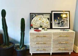 a white cabinet with two cactuses and a picture on it at Charming Studio West Village in New York