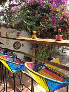 deux chaises colorées assises sur une table fleurie dans l'établissement Tree of Life - Hostel, à Barichara