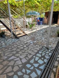 a stone walkway with an umbrella and a patio at Zhanas home anaklia in Anaklia