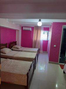 a room with four beds and pink walls at Zhanas home anaklia in Anaklia
