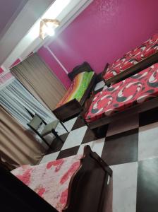 a room with two beds and a checkered floor at Zhanas home anaklia in Anaklia