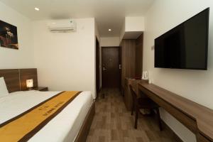a hotel room with a bed and a flat screen tv at Sonne Hotel Quang Binh in Ðộng Hỏi +7 photos