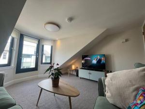 a living room with a couch and a tv at Flat in Gourock - The Wedge in Gourock