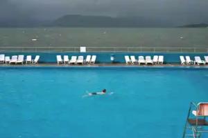 - une personne se baignant dans une piscine avec des chaises dans l'établissement Flat in Gourock - The Wedge, à Gourock