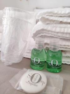 due bottiglie di liquido verde sedute su un tavolo con asciugamani di B&b Sedilequattro a Castellaneta