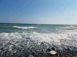 a rocky beach with waves and the ocean at Beach apartments in Limassol