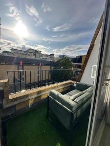 a balcony with a couch on top of a building at Modern flat in Victoria in London