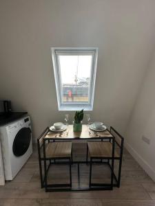 a table and chairs in a room with a window at Modern flat in Victoria in London