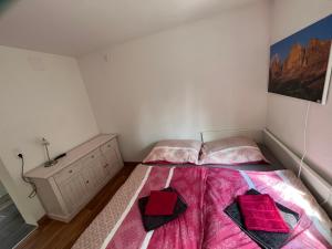 a bedroom with a bed with pink sheets and a dresser at Binis Murtalblick in Pöls