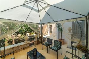 un patio interior con una gran sombrilla blanca en Il colore del Salento, en Carpignano Salentino