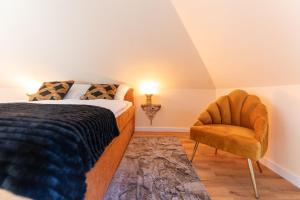 sypialnia z łóżkiem i krzesłem w obiekcie Juwel am Meer - Achat w mieście Bad Zwischenahn
