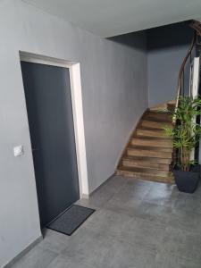 un pasillo con una puerta y una escalera con plantas en Logement chaleureux 2 personnes, en Saint-Gaudens