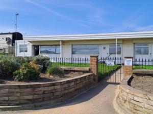 a building with a fence in front of it at Sandhaven Beach Chalets in South Shields