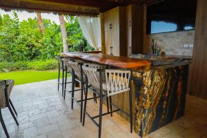 an outdoor kitchen with a marble counter and stools at Casa de Playa Espectacular Casa del Sol in Ayangue