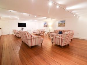 ein Wartezimmer mit Stühlen und einem Flachbildfernseher in der Unterkunft The Old Gymnasium in Southwold