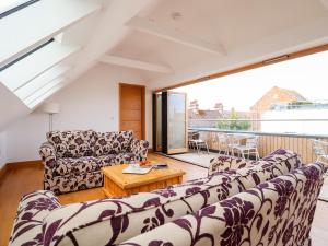 ein Wohnzimmer mit Sofas und einem Tisch in der Unterkunft The Old Gymnasium in Southwold