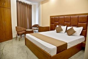 a bedroom with a large bed with a wooden headboard at HOTEL AROMA CROWN in Zirakpur
