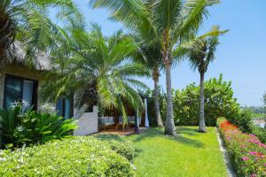une maison avec des palmiers et une cour fleurie dans l'établissement Casa de Playa Espectacular Casa del Sol, à Ayangue