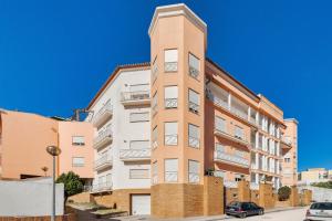 ein Apartmenthaus mit einem hohen Turm in der Unterkunft Rosa in Torres Novas