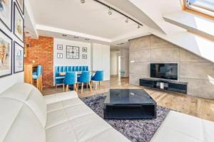 a living room with a white couch and a fireplace at Golden Apartments Gdansk&SwB12 in Gdańsk